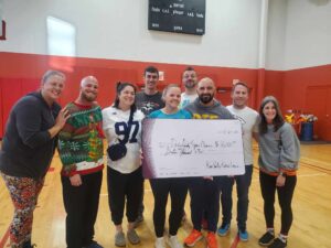 Group of people holding a large check, made out for $16,000